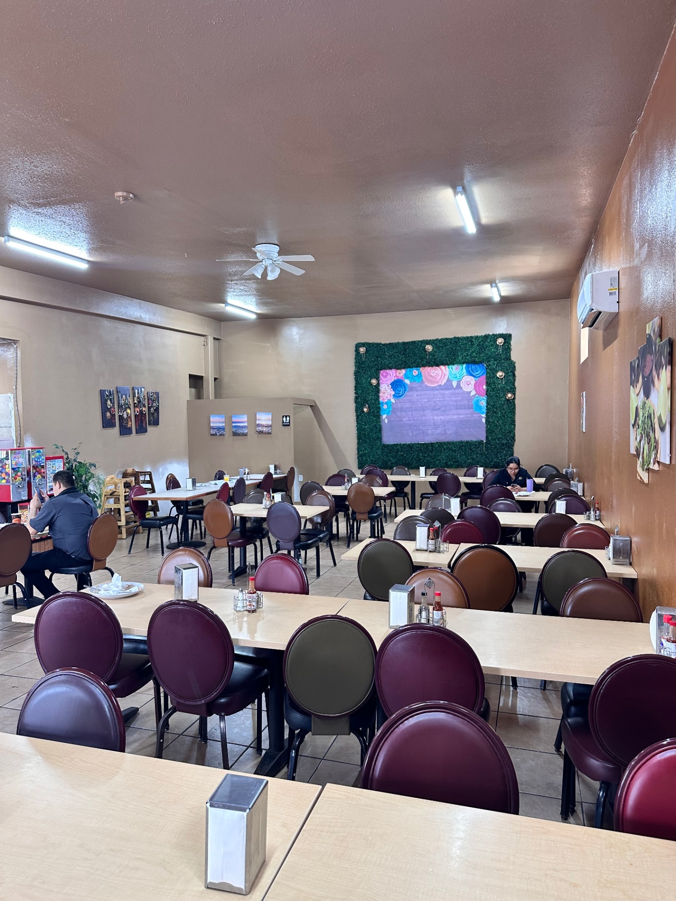 Los Amigos dining room with floral mural and ceiling fans