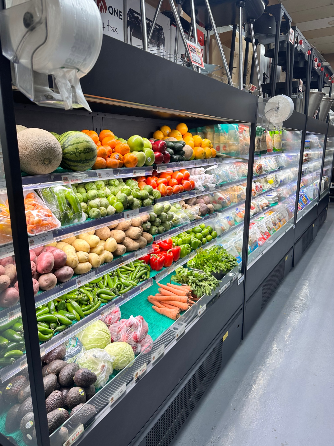 Fresh produce wall with melons, chiles, tomatillos, and potatoes