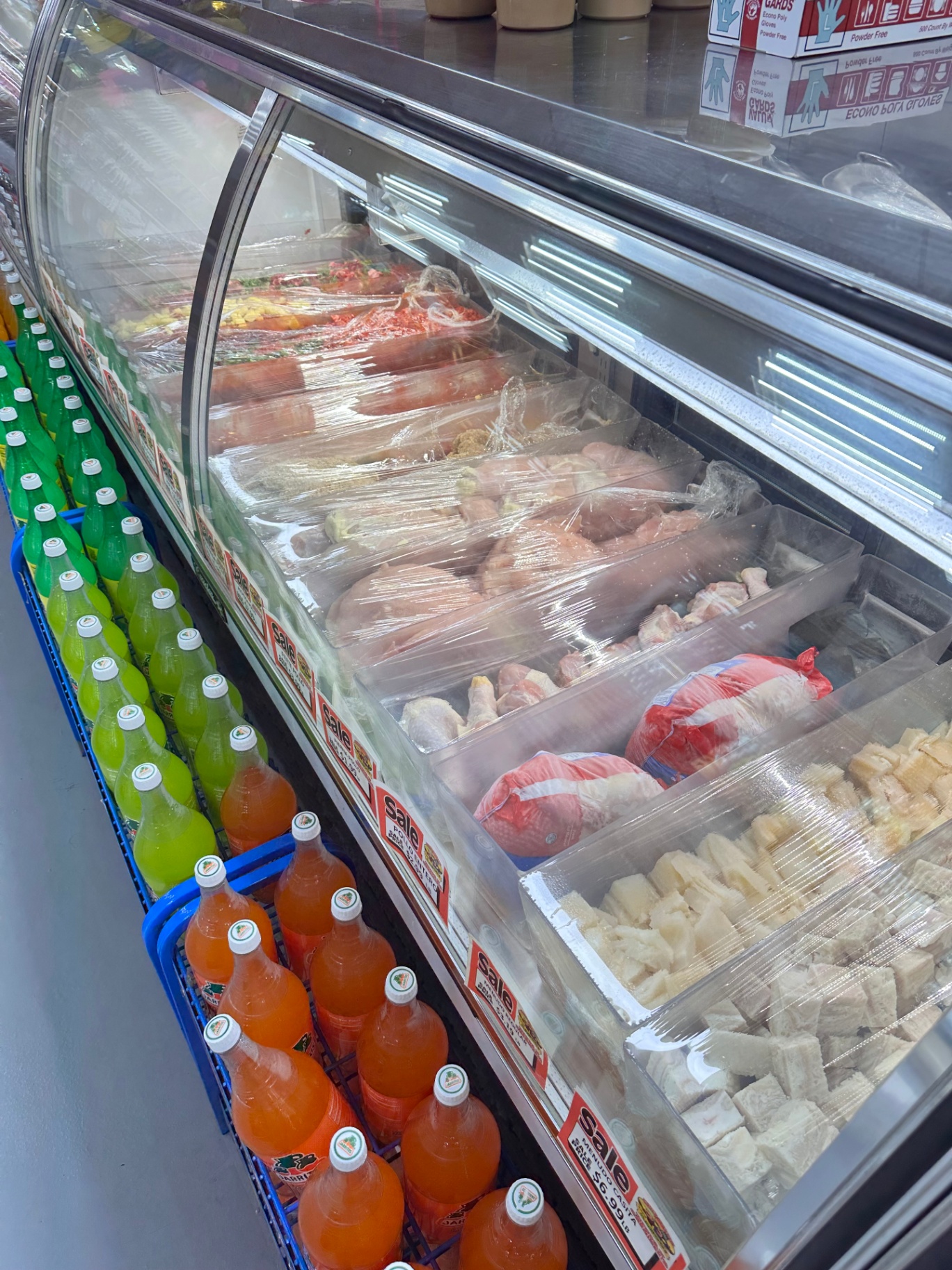 Whole chicken, drumsticks, and cod fillets in the meat case