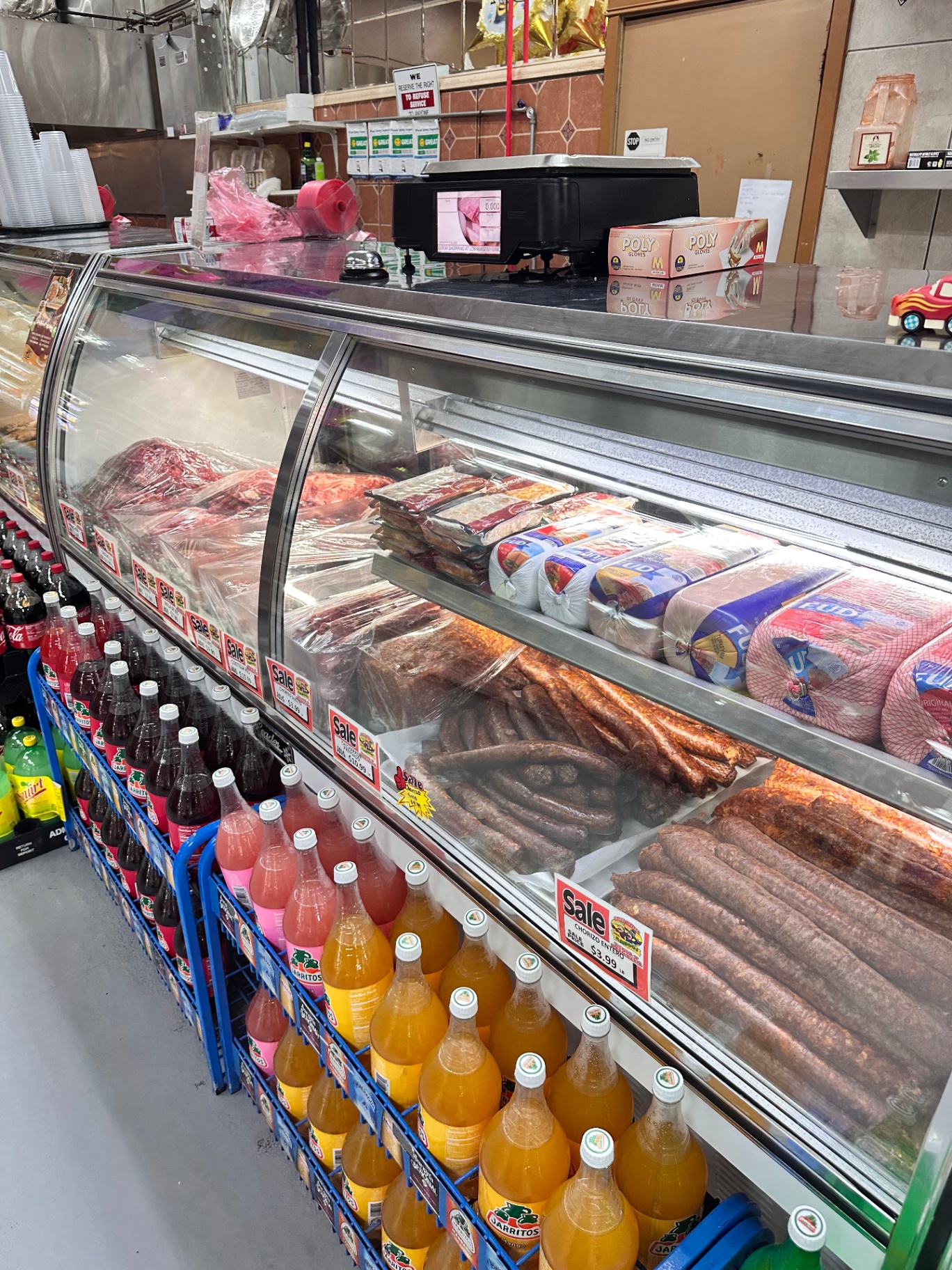 Carnicería case with fresh meats, chorizo links, and hams